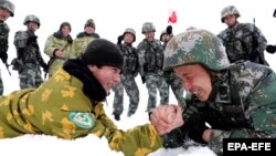 Chinese and Tajik soldiers arm wrestle during patrols near the city of Kashgar, in the northwestern autonomous region of Xinjiang, in May 2019.