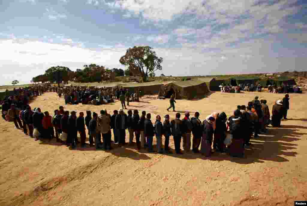 Egyptian refugees fleeing violence in Libya line up to be processed at a refugee camp after crossing into Tunisia near the border crossing of Ras Jdir in February 2011.