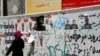 An Iranian woman walks past campaign posters in Tehran on June 8.