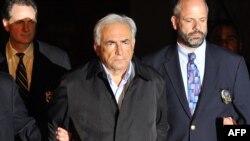 IMF head Dominique Strauss-Kahn (center) is taken out of a police station in handcuffs in New York on May 15.