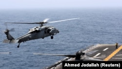 A helicopter lands on the deck of USS Boxer in the Arabian Sea off Oman in July 2019.