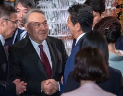 Назарбаев Жапония премьері Синдзо Абемен қол алысып тұр. Токио, 23 қазан 2019 жыл.