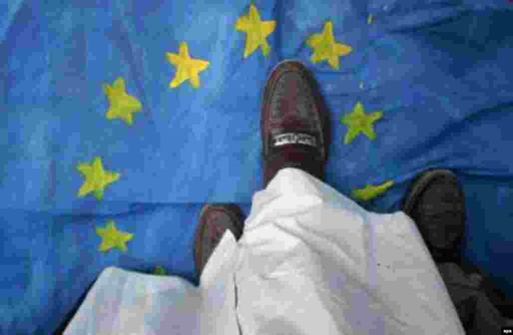 A man in Pakistan treads on an EU flag during a February demonstration in Karachi (epa) - In March, moderate Bosnian Muslim leader Reisu-UI-ulema Mustafa Ceric told RFE/RL that European Muslims can play a unique role in bridging the gap between the Islamic world and the West.