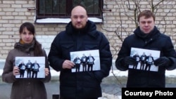 In a Facebook photo, three people, including Uladzimer Labkovich (right), hold up photos of the "Byalyatski Three" activists, who are themselves brandishing images of jailed rights activist Ales Byalyatski.