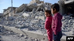 Children stand in a destroyed street in the northwestern border town of Al-Bab on February 23.