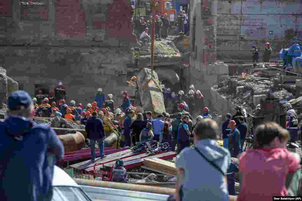 Russian Emergency Situations Ministry rescuers work at the site of a collapsed wall during reconstruction of a building in Novosibirsk. At least three people were killed. (AP/Ilnar Salakhiev)