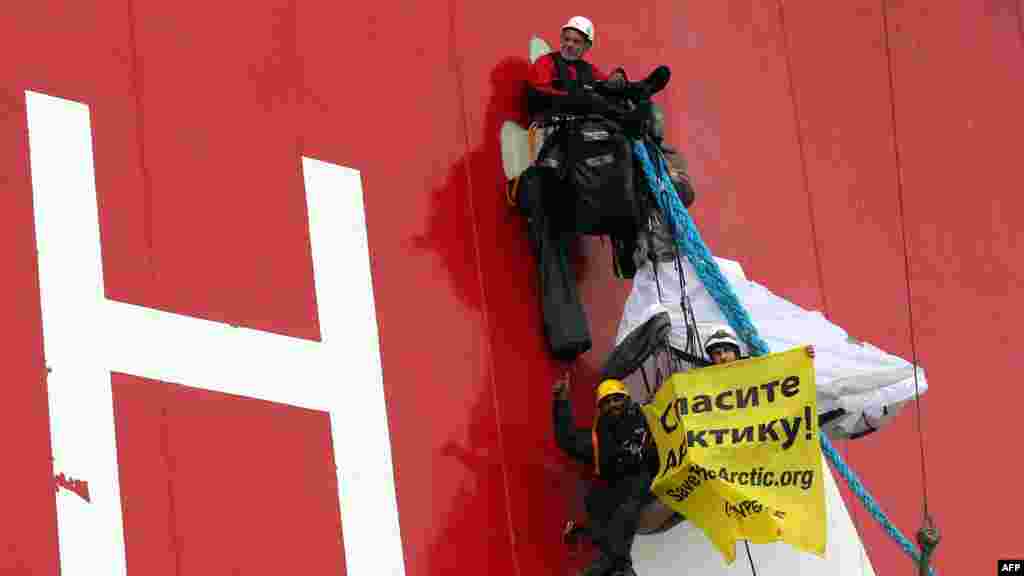 Greenpeace Executive Director Kumi Naidoo (bottom) gives a thumbs up as he and other activists board Gazprom&rsquo;s &quot;Prirazlomnaya&quot; Arctic oil platform during a protest off Russia&#39;s northeastern coast on August 24. (AFP/Denis Sinyakov)