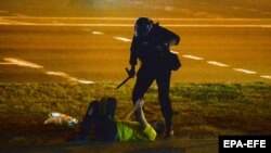 Belarusda polisiýa işgäri protestçiniň üstüne abanyp dur. 