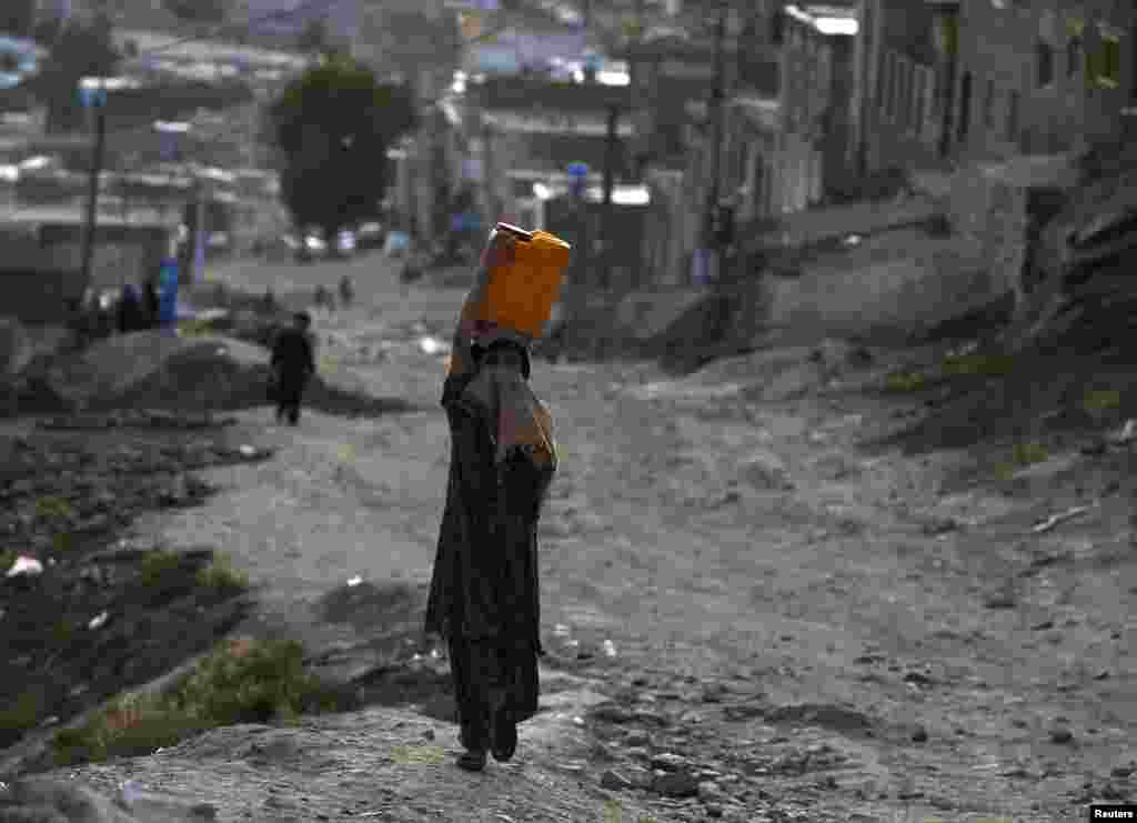 An Afghan girl carries a water container on her head in Kabul on June 5 (Reuters/Omar Sobhani)