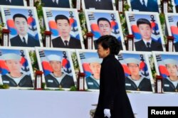 Пак Кын Хе смотрит на фото 46 южнокорейских моряков, погибших на корвете "Чхонан" 27 марта 2010 года, как считают в Сеуле, в результате атаки субмарины КНДР.