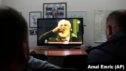 Bosnian people watch a live TV broadcast from the International Criminal Court for the former Yugoslavia in The Hague as Slobodan Praljak brings a bottle of what he said was poison to his lips on November 29. The former Bosnian-Croat general's death was confirmed by the UN hours later. 