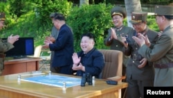 Лидер Северной Кореи Ким Чен Ын наблюдает за запуском баллистической ракеты.