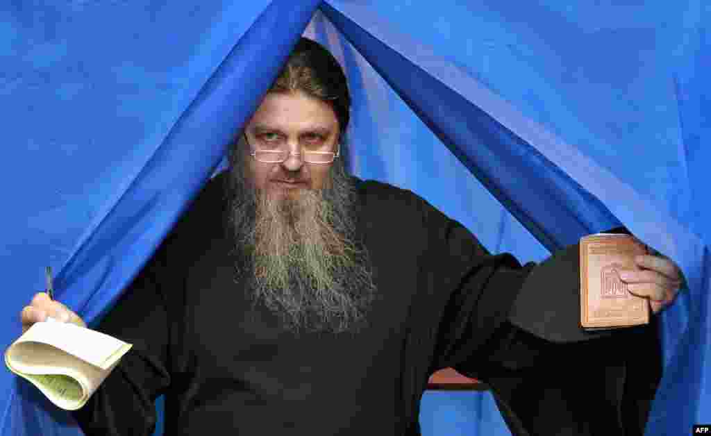 An Orthodox priest leaves a ballot booth at a polling station in Kyiv.