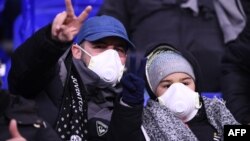 Болельщики сидят в масках на матче Лиги чемпионов, до того, как турнир закрыли на карантин, февраль 2020 год 