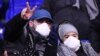 Люди вдягли маски на обличчя як запобіжний захід проти коронавірусу під час футбольного матчу «Ліон» – «Ювентус»