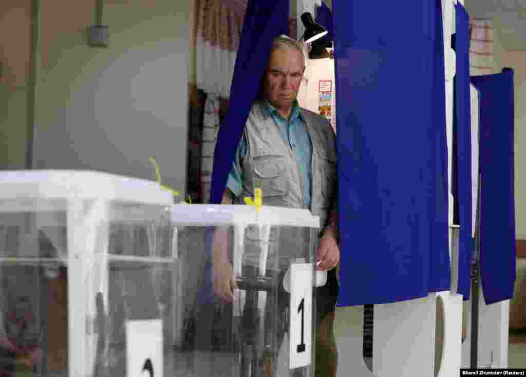 A man walks out of a voting booth at a polling station in Moscow.