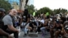 Полицейские встали на колено вместе с протестующими во время акции протеста из-за гибели после задержания полицией афроамериканца Джорджа Флойда, Атланта, 1 июня 2020 года.