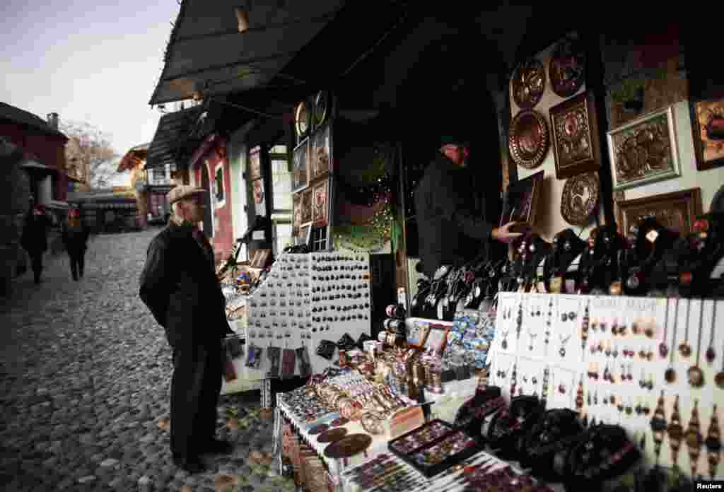 A man stands in front of a souvenir shop in the historic center.
