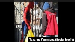 Человек-паук помогает людям на улице. Иллюстративное фото