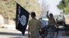 FILE: A rebel fighter takes away a flag that belonged to Islamic State militants in Syria's northern Aleppo Governorate in October.