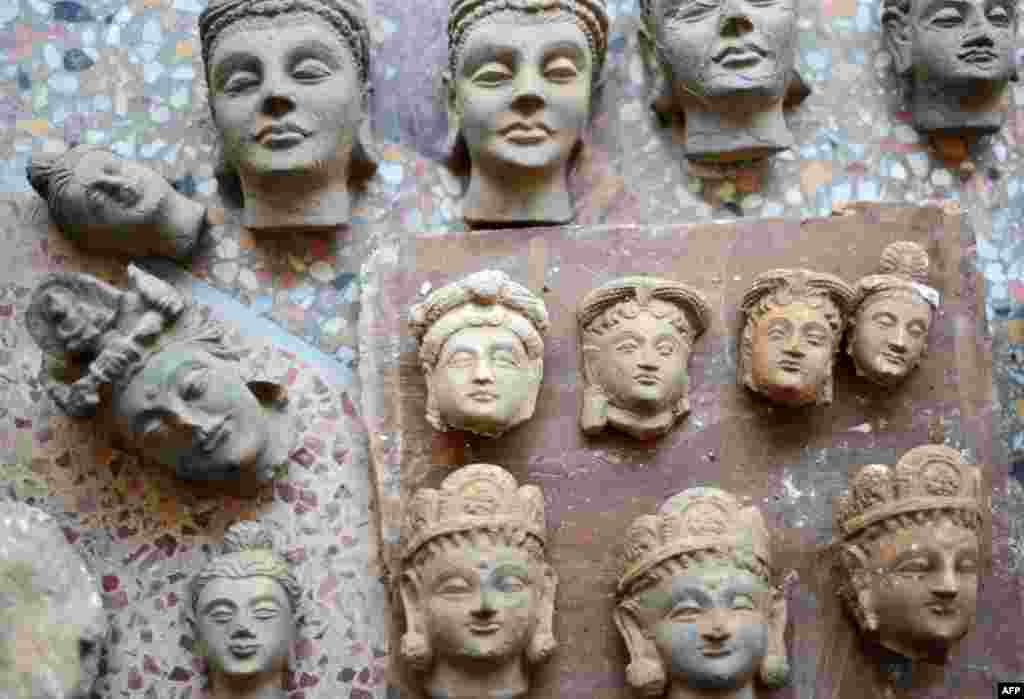 An original Buddha head (center top) sits among recently made copies at Taxila in Punjab Province in Pakistan.