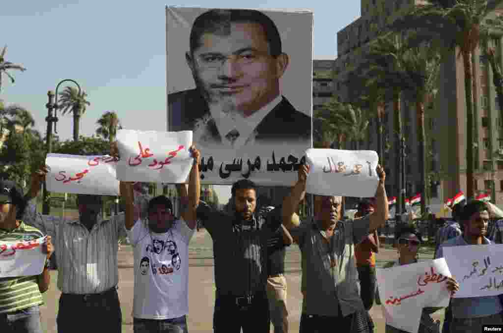 Misirdə etirazçılar indiki prezident Mohamed Mursi ilə keçmiş prezident Hosni Mubarak-ın fotolarını birləşdirməklə ölkədə heç nəyin dəyişmədiyinə eyham vururlar.