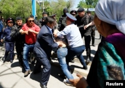 Жер митингісіне шықпақ болған азаматтарды ұстап жатқан полицейлер. Алматы, 21 мамыр 2016 жыл.