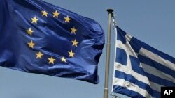 Greece -- EU and Greece flags flie above the ancient Parthenon temple, on the Acropolis Hill, in Athens, 11Jul2011