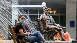 Масқа таққан қыз көшеде отыр. Алматы, 22 маусым 2020 жыл.