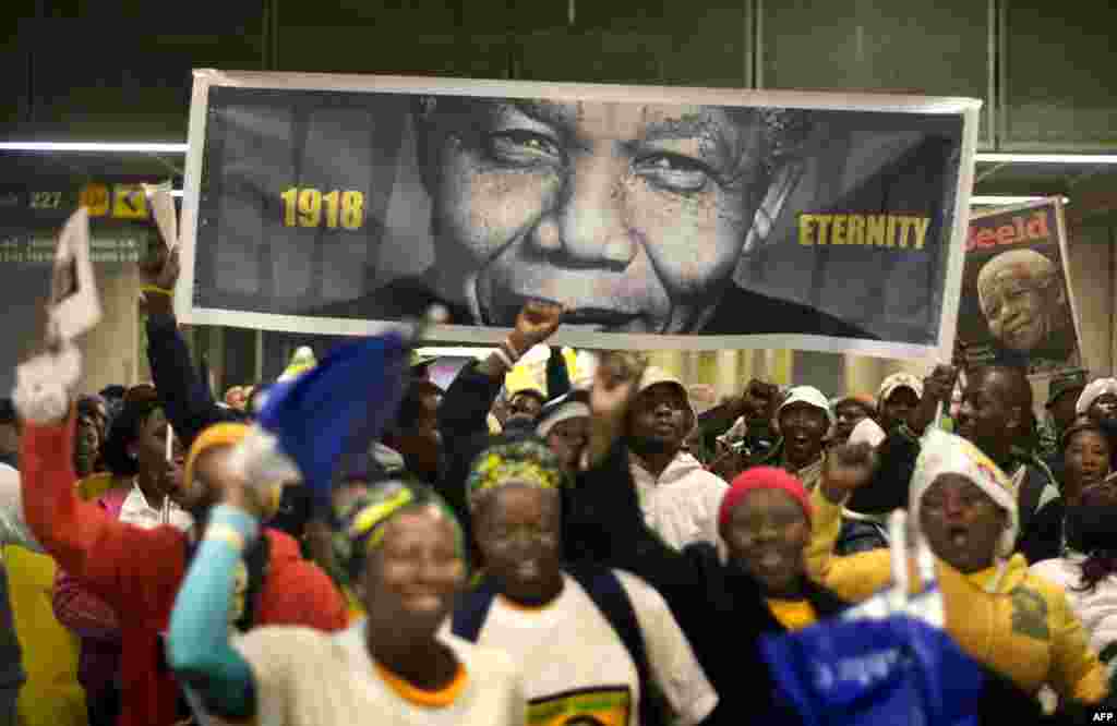 People arrive at the First National Bank (FNB) Stadium, also known as Soccer City, ahead of the national memorial service for late President Nelson Mandela in Johannesburg.