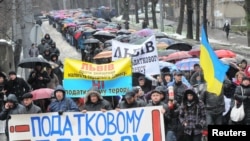 Demonstrators against the tax changes march during a protest in Lviv on November 29.