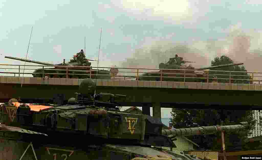 The crew of a British &quot;Challenger&quot; tank keeps a watchful eye on Yugoslav Army tanks on a bridge as they leave Pristina in June 1999. &nbsp;