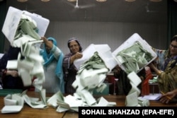 Polling officers count ballots at a polling station in Islamabad.