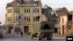 A truck passes by a ruined house in the town of Vukovar, which was left devastated by the Balkan conflict. (file photo, taken October 1992)