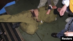 Ізраїльський спецназівець у руках пропалестинських активістів під час десанту на судно 31 травня 2010 року