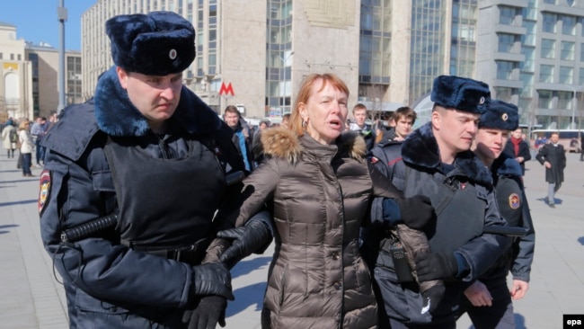 Russian police detain a protester ahead of an opposition rally in central Moscow.