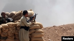 Kurdish Peshmerga troops stand guard during an intensive security deployment against Islamic State militants on the outskirts of the province of Nineveh on August 6. 