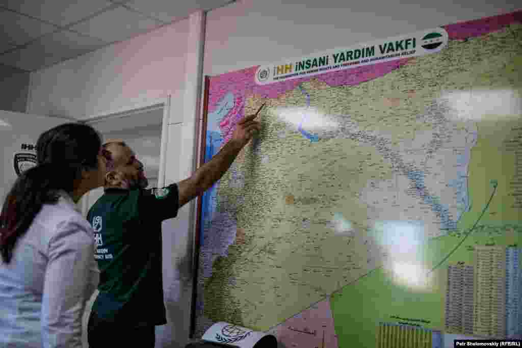 The head of the IHH facility shows a journalist a map of camps they operate inside Syria.