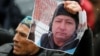 A man holds a photo of Kazakh activist Dulat Aghadil during a commemoration meeting in Almaty on February 27.