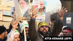 Demonstruesit iranianë mbajnë imazhet e komandantit ushtarak të vrarë Qasem Soleimani dhe Liderit të Lartë të Iranit Ayatollah Ali Khamenei përpara ambasadës britanike në kryeqytetin Teheran më 12 janar 2020. 