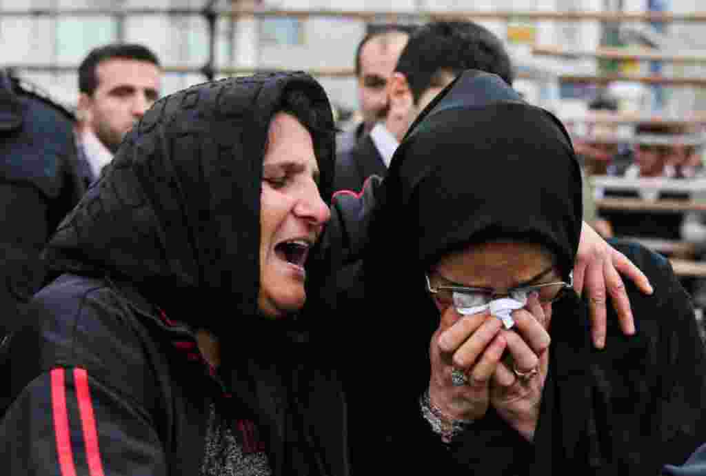 The mother of Balal, left, and the mother of Abdollah, the victim, cry together.