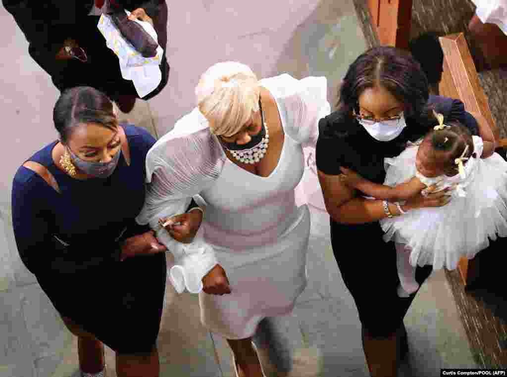 Tomika Miller, the wife of Rayshard Brooks, has to be helped out of the sanctuary at the conclusion of his funeral in Ebenezer Baptist Church with their 1-year-old daughter Dream watching on June 23, 2020 in Atlanta, Georgia.