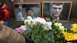 Мәскеудегі Борис Немцов қаза тапқан жердегі саясаткердің суреті мен гүл.