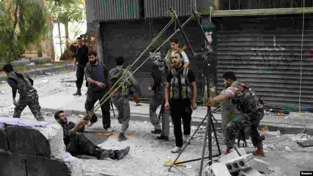 Membri ai Armatei Libere Siriene folosesc o catapultă pentru a lansa o bombă artizanală &icirc;mpotriva truipelor guvernamentale la Alep, Siria, 15octombrie. (REUTER/Asmaa Waguih)