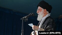 IRAN -- Iranian supreme leader shows Ayatollah Ali Khamenei (L) delivering a speech after the Eid al-Fitr prayers at the Imam Khomeini grand mosque in the capital Tehran, June 15, 2018