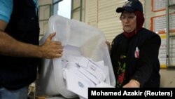 A Lebanese election official empties a ballot box after the polling station closed during Lebanon's parliamentary elections, in Beirut on May 6.