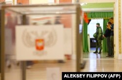 A serviceman guards the entrance to a polling station in Donetsk during voting on November 11.