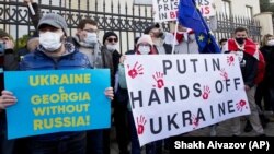 Грузинські активісти тримають плакати на акції з підтримки України перед посольством України в Тбілісі. Грузія, 23 січня 2022 року