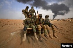 Forțele de Mobilizare Populară șiite avansează spre orașul Al-Qaim, Irak, în 2017.