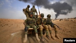 Shi'ite Popular Mobilization Forces advance toward the city of Al-Qaim, Iraq, in 2017.